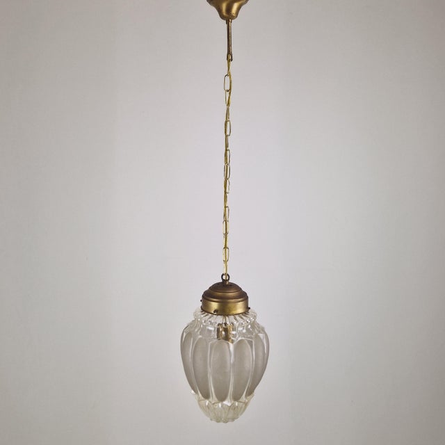 Striking and elegant Italian pendant lamp attributed to Mazzega, executed in Murano glass and brass during the 1970s. The...