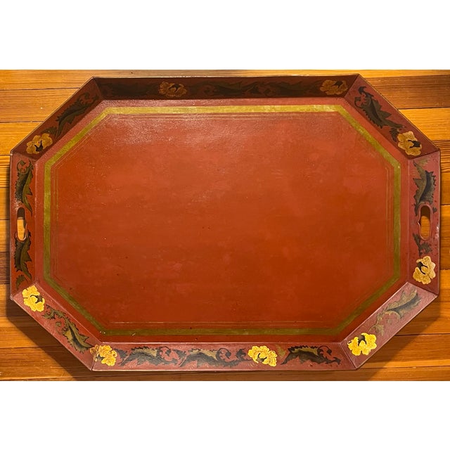 A fine Regency tole tray of octagonal shape with brick red ground and gilt border of leaves and flower heads dating from...