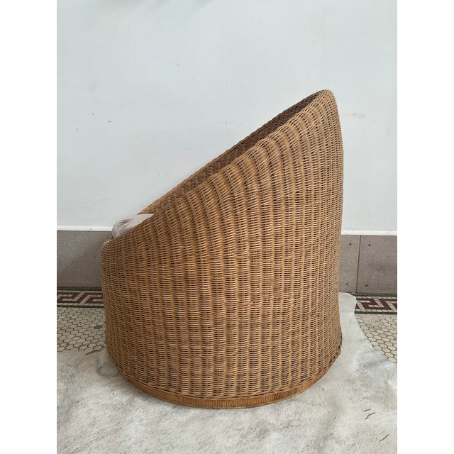 Embrace a sophisticated blend of organic texture and tailored luxury with this striking vintage wicker barrel chair....