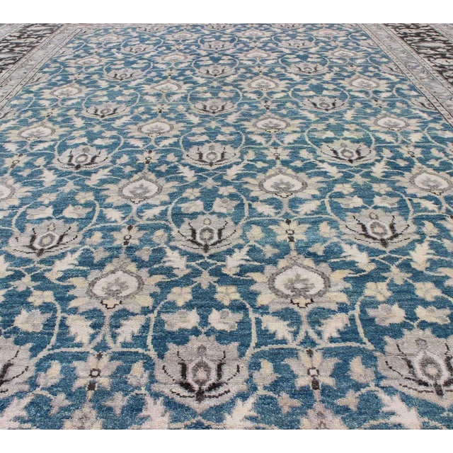 Measures: 10'0 x 14'0 This hand knotted Tabriz rug features a beautiful all-over design rendered in grays, silver, and...