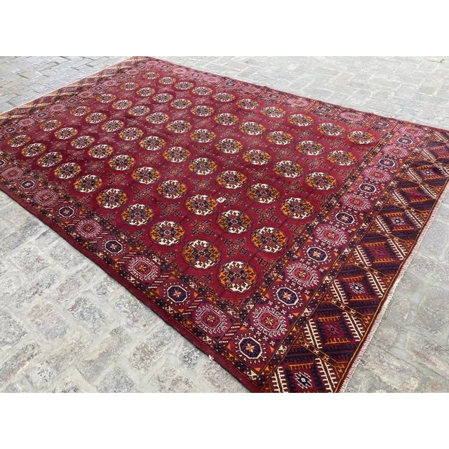 Discover the 6'11" x 10'11" hand-knotted authentic Turkmen Tekke rug, featuring rich Gul patterns in vibrant colors....