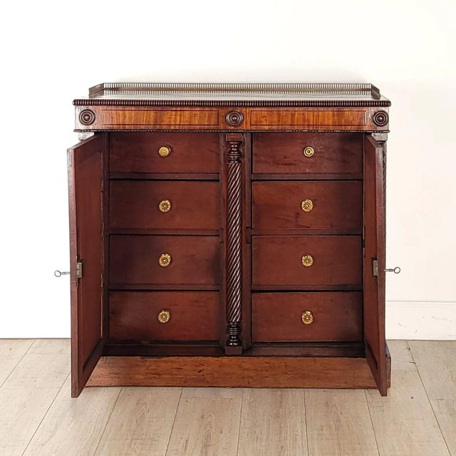 An English Regency period mahogany cabinet with pierced brass gallery. Two doors open to eight drawers. Great storage,...