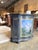 Vintage curved front cabinet finished in distressed black with a hand painted scenic panel across the doors. The painting...