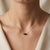 Bring grounded mystery to your style with this rich two-stone pendant necklace, featuring two sparkling smoky-brown heart-...