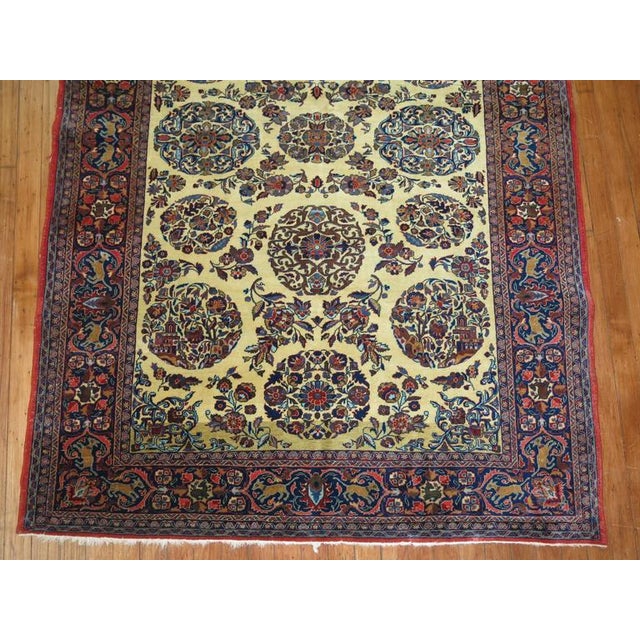 An enchanting early 20th century finely woven Persian Kashan rug with a bone colored field and navy blue pictorial animal...