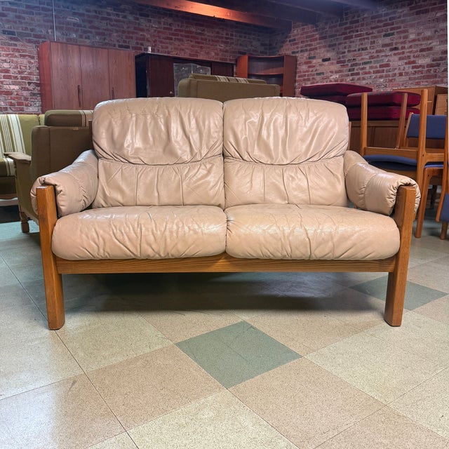 Vintage Scandinavian modern two-seater Stressless sofa produced by Ekornes of Norway. Sofa features light neutral-colored...