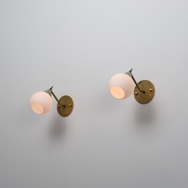 Pair of Italian wall sconces from the 1950s characterized by a compact and well-balanced mid-century design. Each fixture...