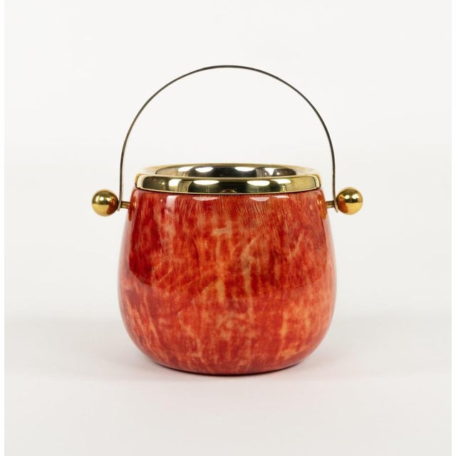 Midcentury beautiful ice bucket in red goatskin and brass with handle by Aldo Tura. Made in Italy in the 1960s. This piece...