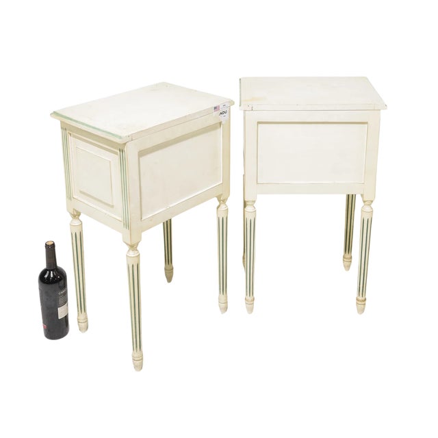 Elegant pair of French Louis XVI–style painted nightstands or occasional tables, each featuring a single drawer and...