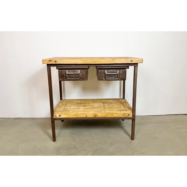 Vintage Industrial worktable from the 1960s. It features a brown iron construction, two wooden plates and two iron...
