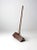 Antique primitive farm tool with a long wooden pole handle and an angled shovel-like bucket base. The hand-hewn...