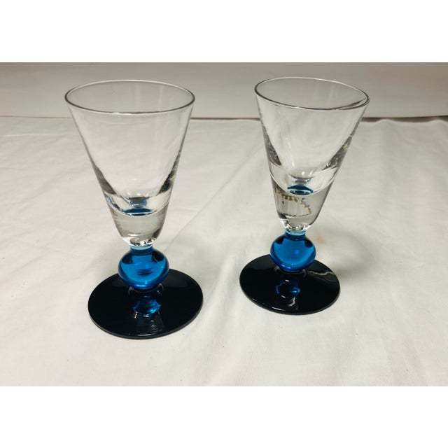 Two cordial fluted glasses with cobalt blue ball stems and base clear flutes
