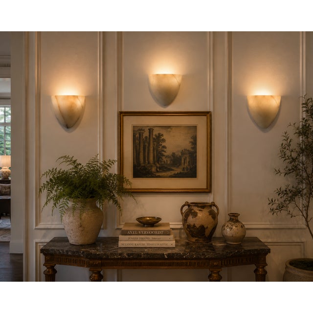 A striking and increasingly hard-to-find set of three vintage wall sconces featuring sculptural shield-form shades hand-...