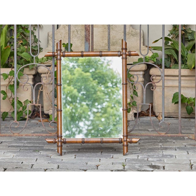 A charming antique faux bamboo mirror from France, dating to circa 1900, with warm brown finish and compact proportions...