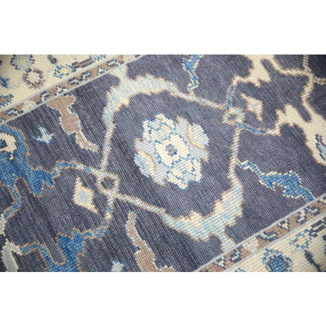 This modern Turkish Oushak rug is a stunning piece of art that has been handwoven using traditional techniques by skilled...