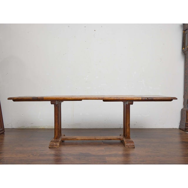 A solid 19th-century French fruitwood dining table with a classic provincial character and a practical extension system....