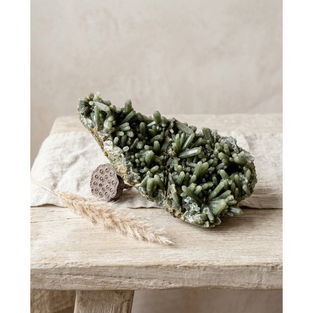A quiet natural Hedenbergite-included quartz cluster selected for its deep forest-green coloration, interlocking prismatic...