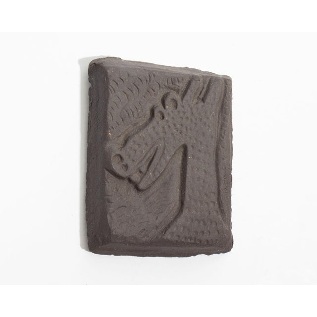 A studio pottery tile by the American artist Mark Bulwinkle (born 1946). This rectangular tile features the impressed...