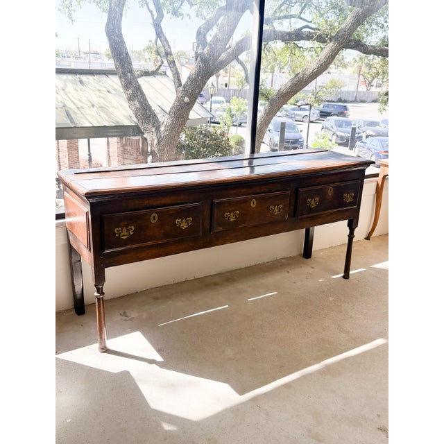 A handsome and 18th-century English country oak dresser base (sideboard), possessing a rich, deep patina and classic...