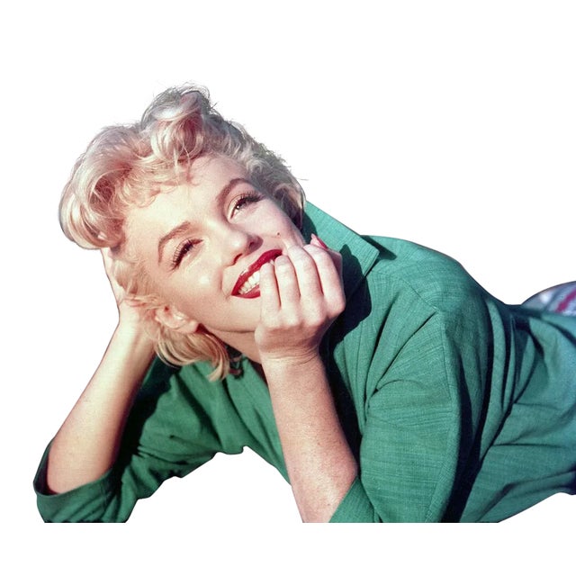 Actress Marilyn Monroe poses for a portrait laying on the grass in 1954 in Palm Springs, California. Photographer: Nahum...