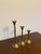 A graduated set of three mid-century modern brass candlesticks with a sleek trumpet silhouette. Each has a slender stem...