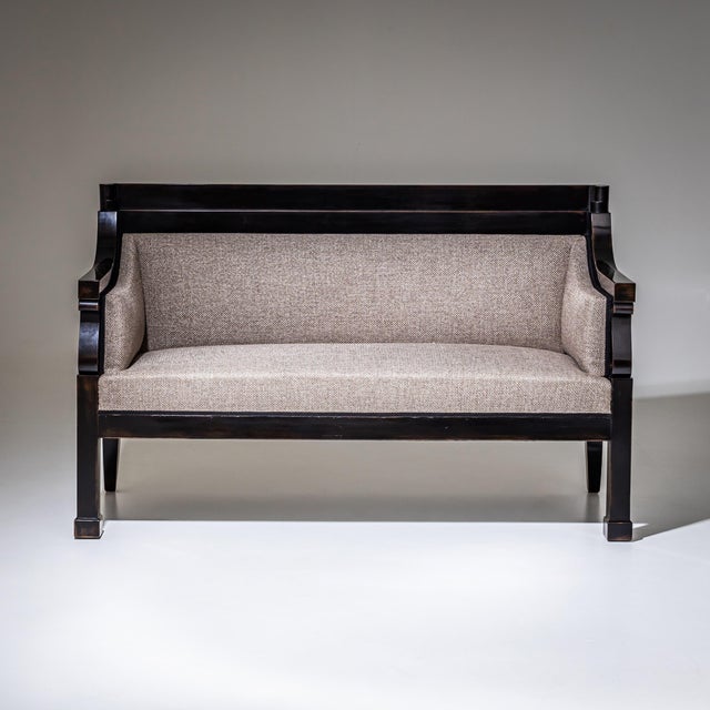 Biedermeier two-seat sofa with a dark brown stained softwood frame and upholstered seat and backrest. The sofa has been...