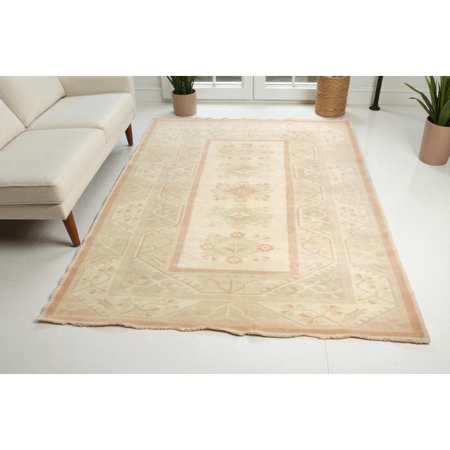 This is a vintage Turkish Oushak rug from the 1960s. The piece was hand-knotted.