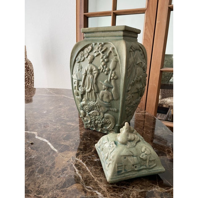 This lidded vase is vintage 1980s. There are four panels with two alike, plus the other two are alike. The surface has a...