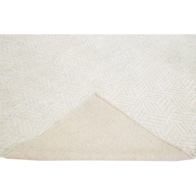 Beautiful modern Moroccan style hand-knotted wool rug with an antique white field. This piece has ivory in the all-over...