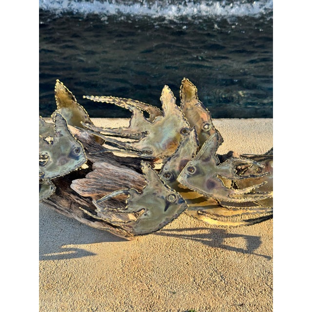 Brutalist vintage decorative metal fish sculpture, mounted on driftwood, in the style of Curtis Jeré. A popular theme in...