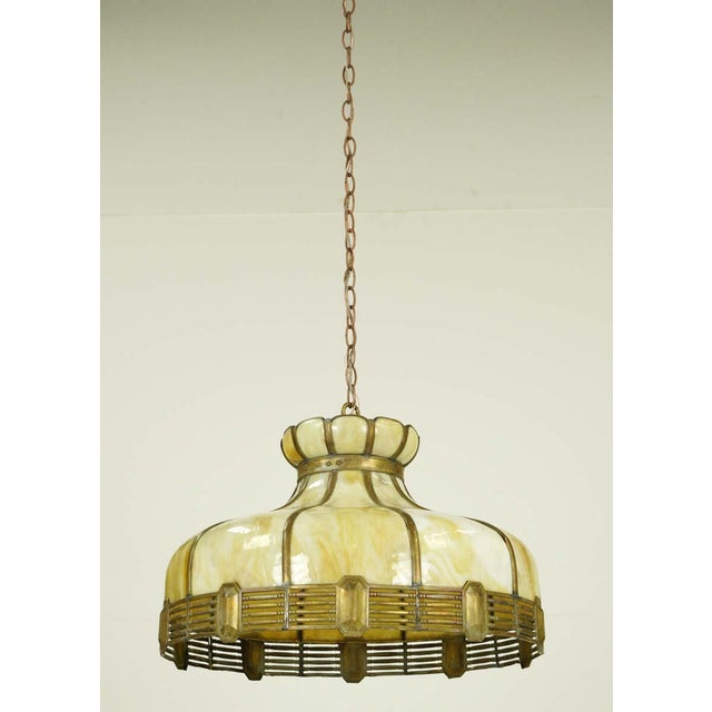 Vintage stained glass pendant light in a mixed tan and white color scheme with an antique brass chain. This requires one...