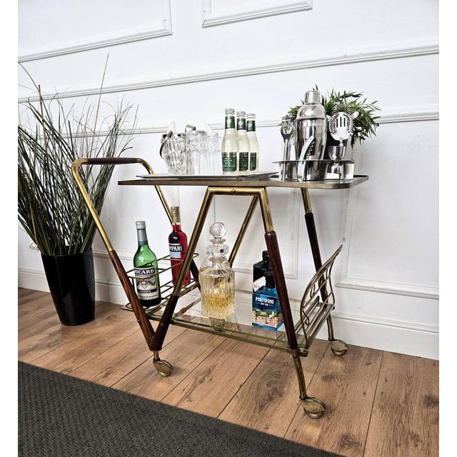 Unique and very elegant Italian Art Deco dry bar cabinet cart with two glass tiers and highlighted by the great wooden and...