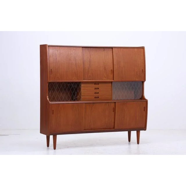 Beautiful danish highboard made of solid teak, designed and manufactured by poul m. Jessen, viby denmark in the 1960s. A...