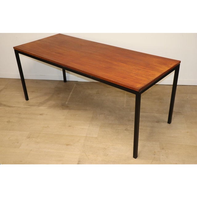 Rectangular dining table designed in the 1950s in a minimalist style. A clean line with this teak top resting on a black...