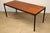 Rectangular dining table designed in the 1950s in a minimalist style. A clean line with this teak top resting on a black...