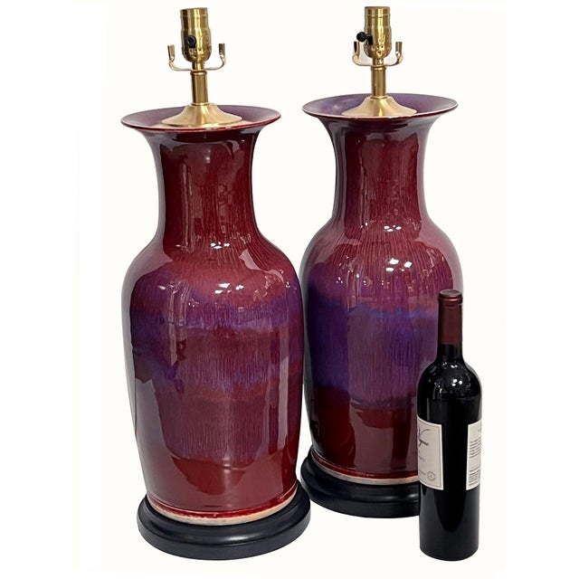 each large and richly glazed vase of baluster form with wiped rim and base featuring striated and speckled oxblood glazed...