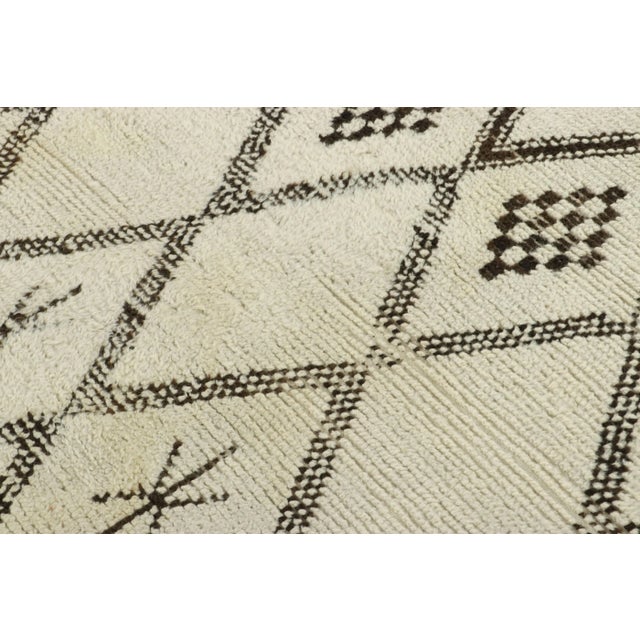 Hand-knotted in wool and originating from Morocco circa 1950-1960, this 6x9 vintage rug is among the most exciting new...