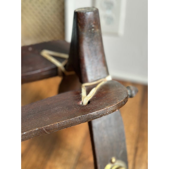 A classic mid-century camel saddle stool featuring a rich, patinated hardwood frame and its original contoured leather...