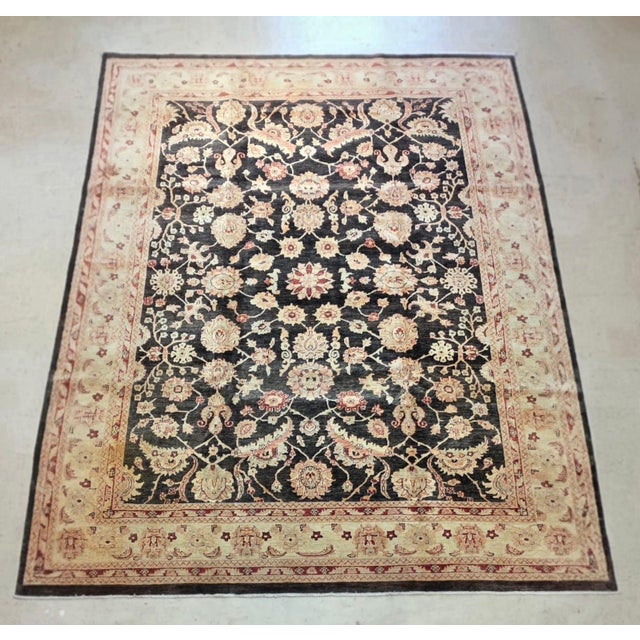 Pak Oushak hand-knotted wool rug, measuring approximately 9’ x 12’5”. The rug features a rich black field filled with an...