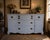 A beautifully crafted vintage French Provincial buffet featuring elegant serpentine lines, carved corner details, and...