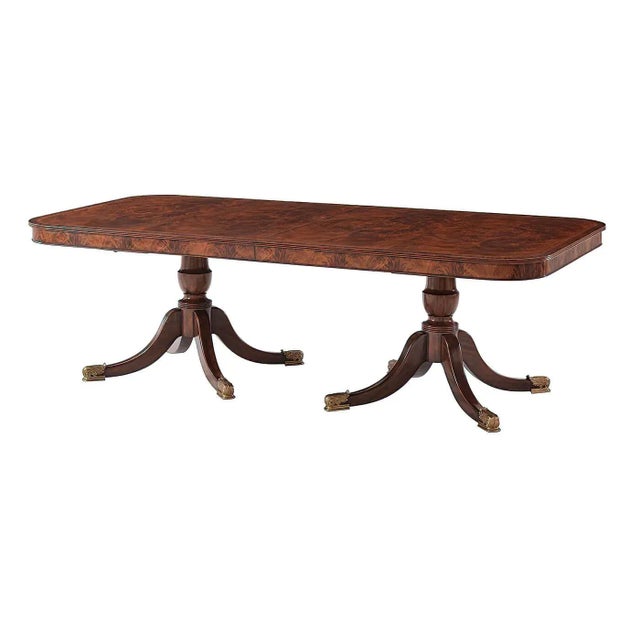 A fine Regency style mahogany and flame veneered extending dining table, the rectangular reeded edge top with rounded...