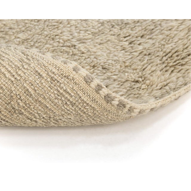 Plush hand-knotted wool rug blending Ivory and Taupe hues for a serene, neutral palette, offering a luxuriously soft...