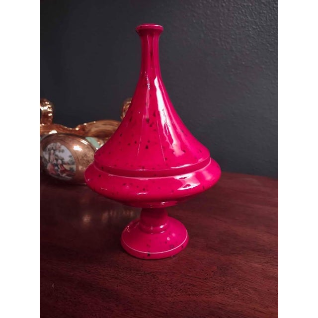 Striking vintage ceramic lidded jar featuring a bold red glaze with black speckled detailing. This sculptural piece makes...
