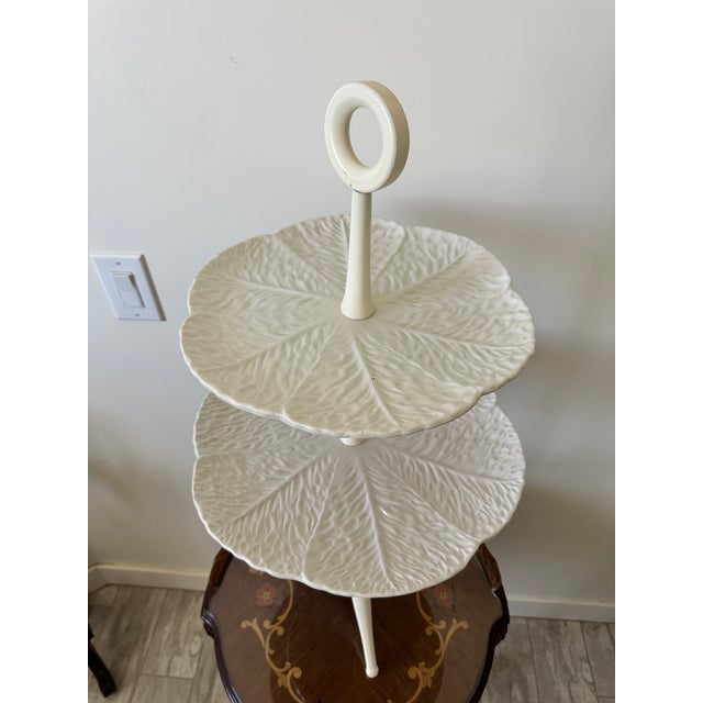 Beautiful white ceramic two tier serving stand featuring embossed leaf-pattern plates and a unique tripod pedestal base....