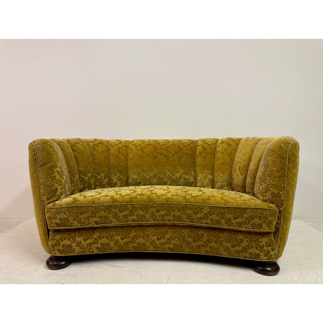 An early 20th century Danish curved sofa, likely dating to the 1930s, with an elegant and sculptural “banana” form. The...