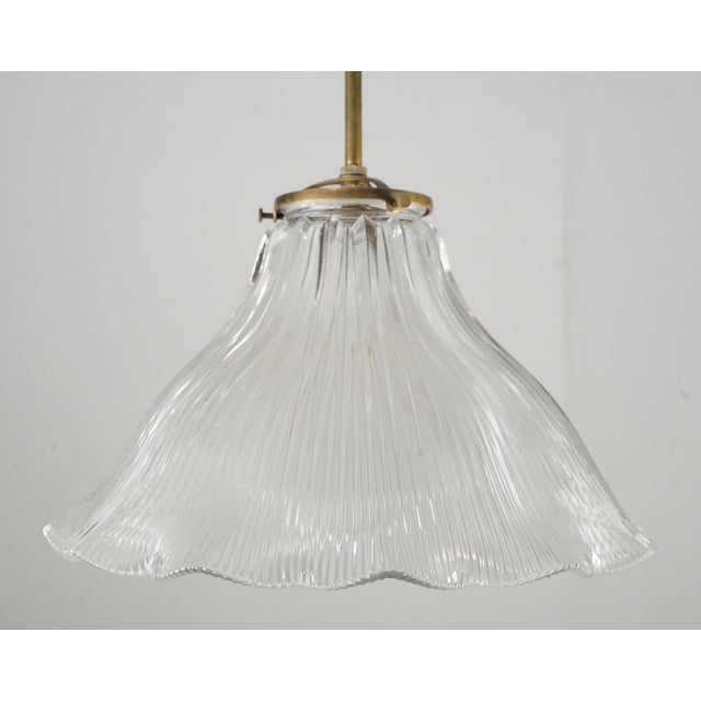 Vintage pendant light made of a clear Holophane style ruffled shade and a newly made brass pole fitter. This requires one...