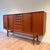 Danish modern teak highboard, circa 1960s, with a beautifully balanced, architectural form. The facade is defined by a...