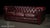 Classic Chesterfield sofa upholstered in richly colored oxblood leather with deep diamond tufting across the back, rolled...