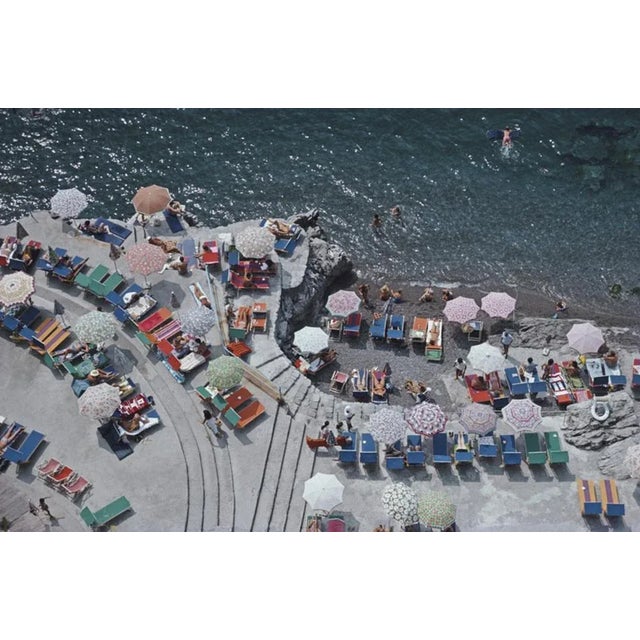 Positano Beach 1979 by Slim Aarons Slim Aarons Limited Estate Edition Elevated view looking down on sunbathers and...