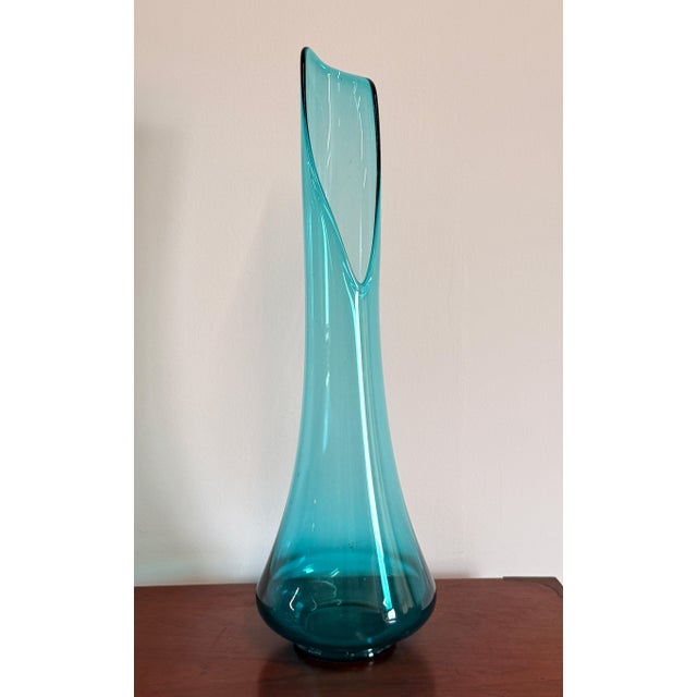 This tall swung vase is a strong example of mid-century American art glass at its most fluid, with a graceful pulled and...